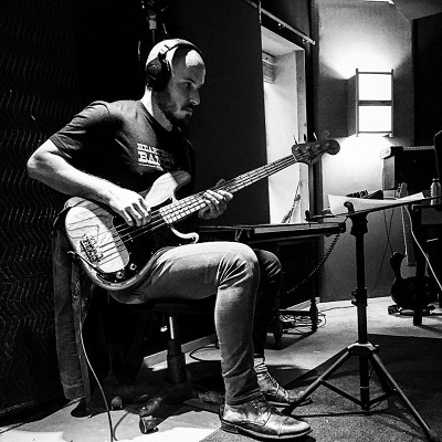 Matt Wigton playing electric bass in a recording studio