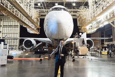 Michal Garcia with his trumpet in front of an Airbus