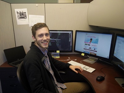 Patrick Carr seated at his desk in a cubicle with ecommerce site on the computer monitor